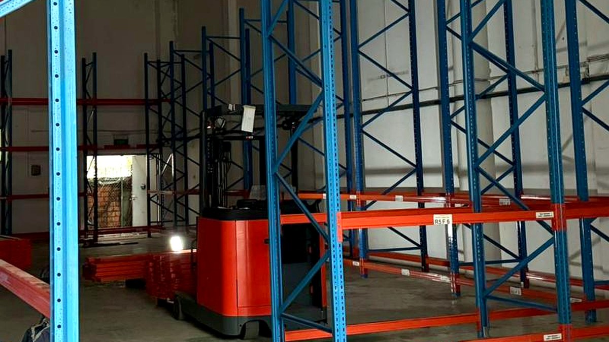 Used electric reach truck among pallet racking in a Singapore warehouse