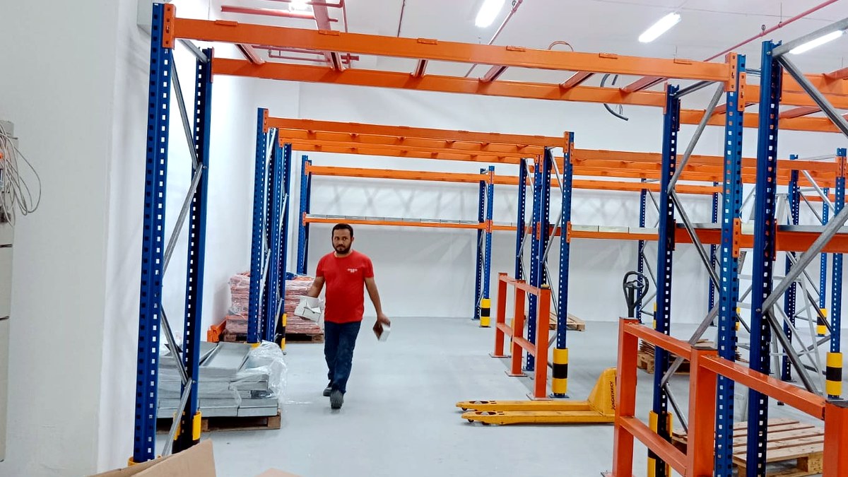 Pallet racking part-installed, beams and frames on the warehouse floor