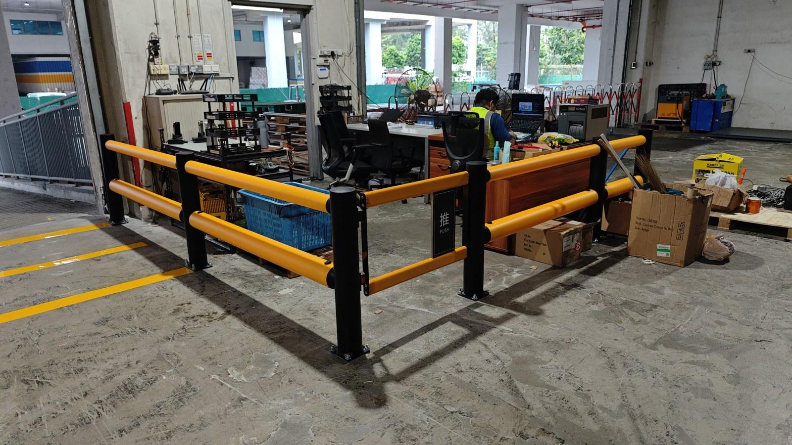 Yellow flexible polymer safety barrier installed around a workstation in a Singapore warehouse